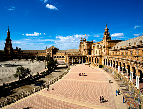 Plaza de España in Seville with tourists exploring the expansive square.