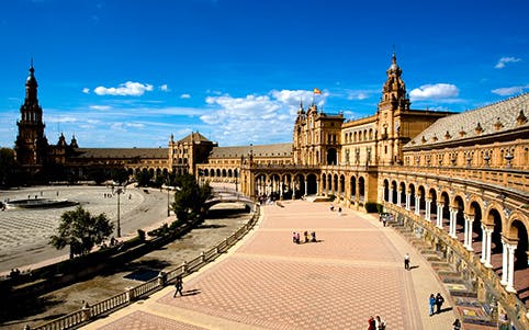 Plaza de España in Seville with tourists exploring the expansive square.