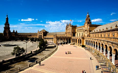 Plaza de España in Seville with tourists exploring the expansive square.