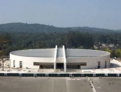 Fatima pilgrimage site with modern basilica, surrounded by forest, part of Algarve tour.