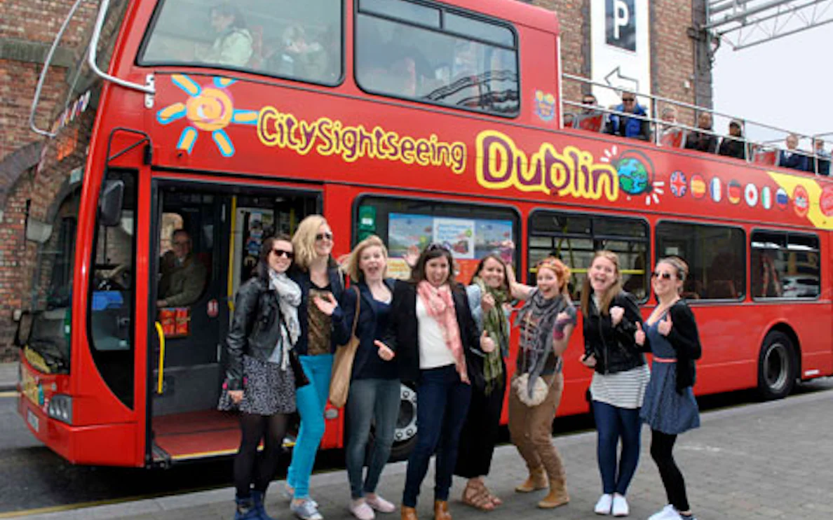 Red double-decker bus for City Sightseeing Dublin with tourists ready to explore.