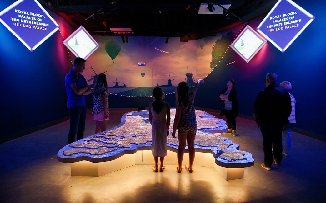 Visitors exploring interactive map at This is Holland exhibit in Amsterdam.