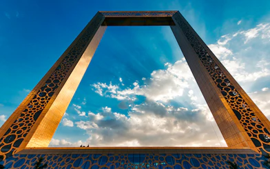 Dubai Frame against a blue sky with clouds.