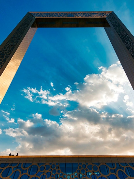 Dubai Frame against a blue sky with clouds.