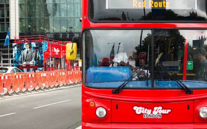 Red double-decker bus on London city tour route.