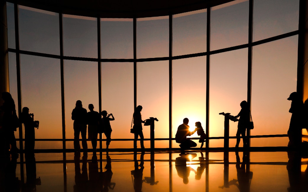 Visitors enjoying sunset views from Burj Khalifa observation deck, Dubai.