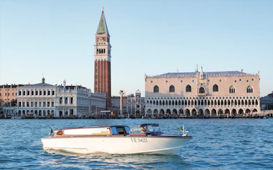 Water taxi on Grand Canal with Doge's Palace and Campanile in Venice.
