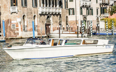 Water taxi navigating Venice canal near historic buildings.