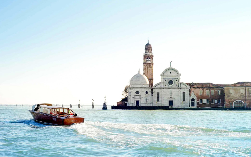 Water taxi near San Michele Island, Venice, with church in background.