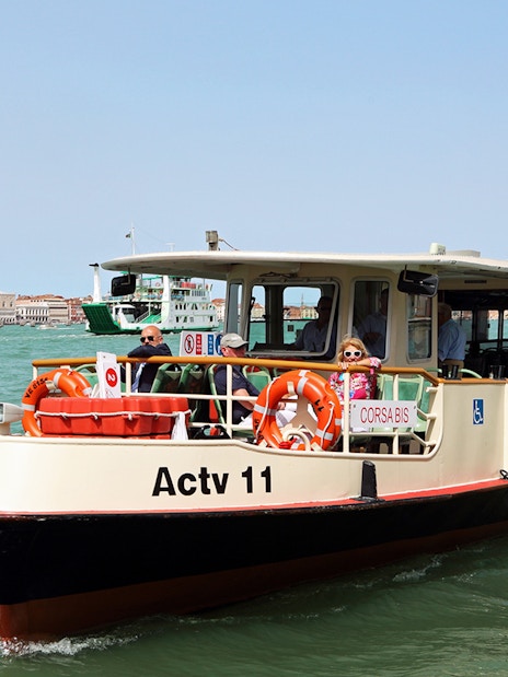 Venice ACTV water bus on Grand Canal with St. Mark's Campanile in background.