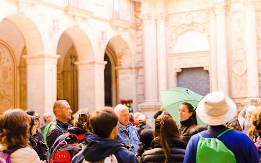 Tour group listening to a guide at Montserrat Sanctuary, Spain.