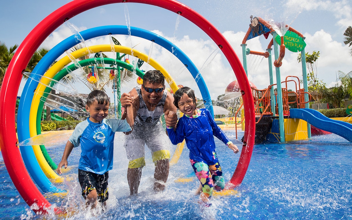 Children and adult enjoying water play area at Wild Wild Wet, Singapore, part of Go City Pass.