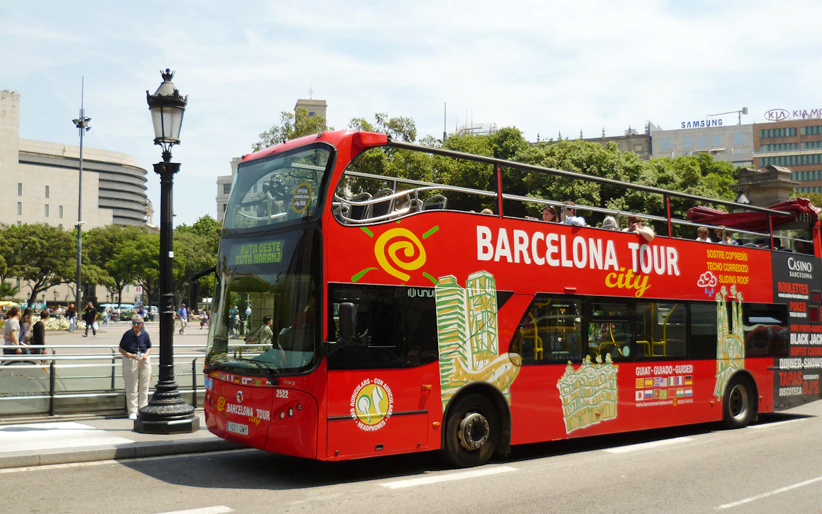 Barcelona hop-on hop-off tour bus near city landmarks.