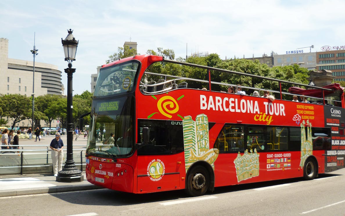 Barcelona hop-on hop-off tour bus near city landmarks.