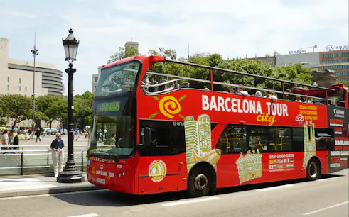Barcelona hop-on hop-off tour bus near city landmarks.