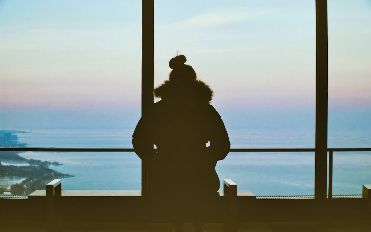 Person viewing Lake Michigan from 360 Chicago observation deck.