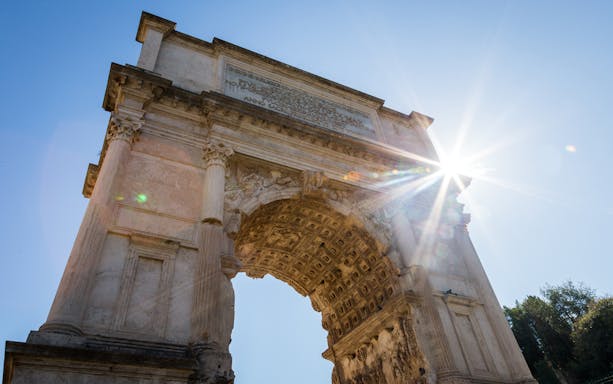 Arch of Titus in Rome with sunlight, part of the Full Day Guided Tour of Vatican and Colosseum.