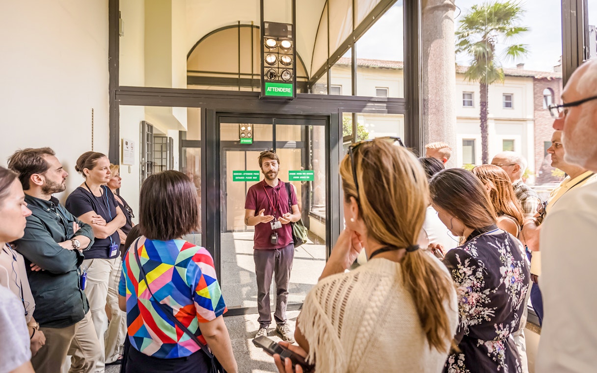 Guide speaking to tourists at The Last Supper Museum entrance.