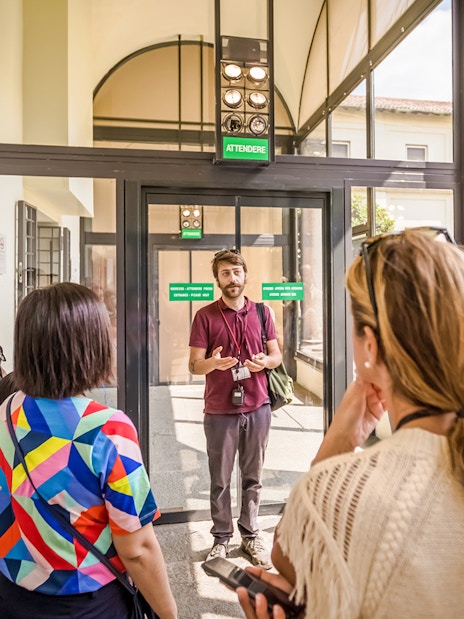 Guide speaking to tourists at The Last Supper Museum entrance.