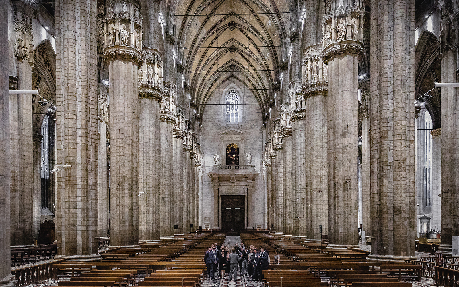 Interior of Duomo Cathedral with towering columns and intricate sculptures, Milan.