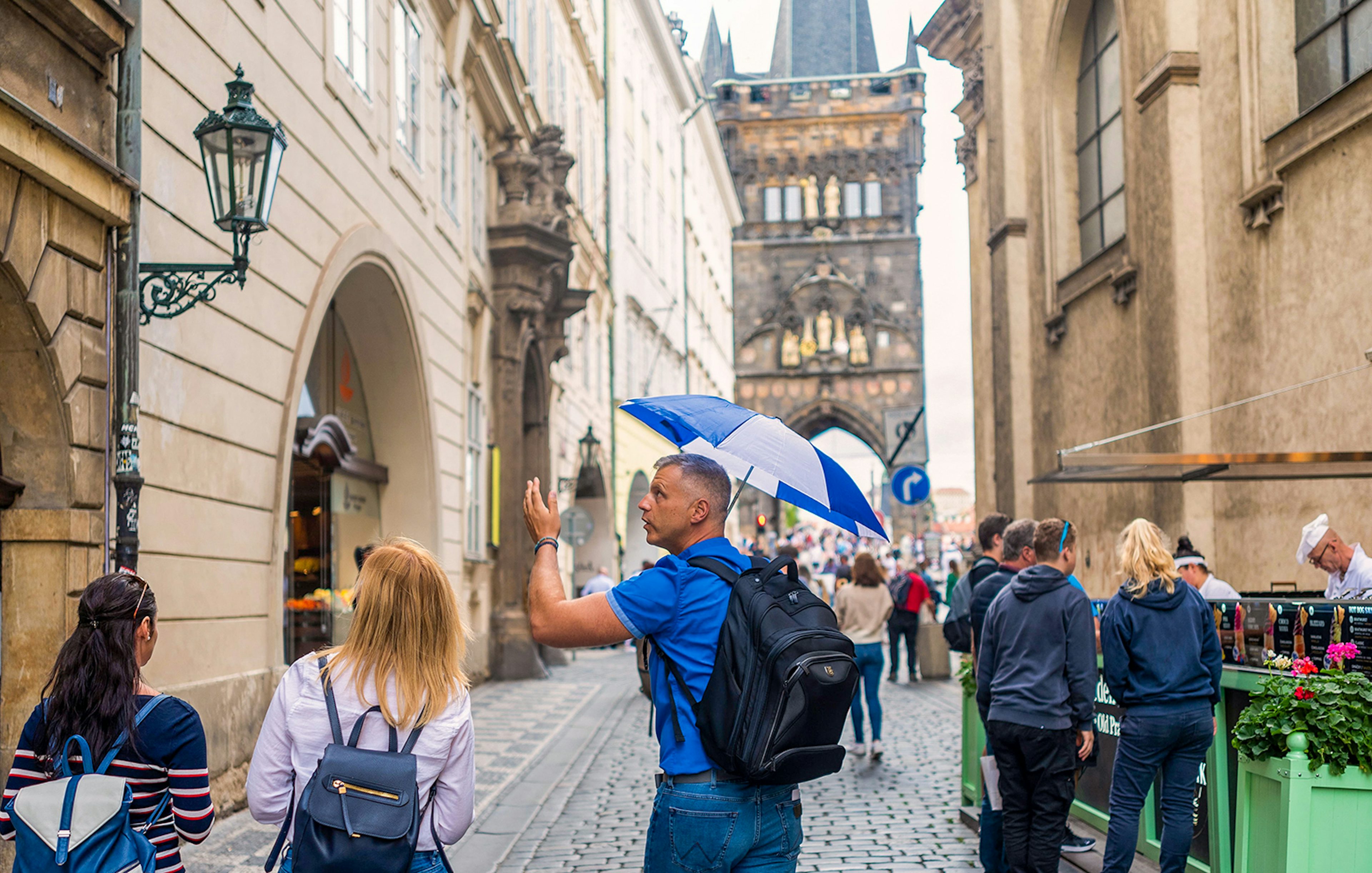 Tour guide leading group near Charles Bridge in Prague.