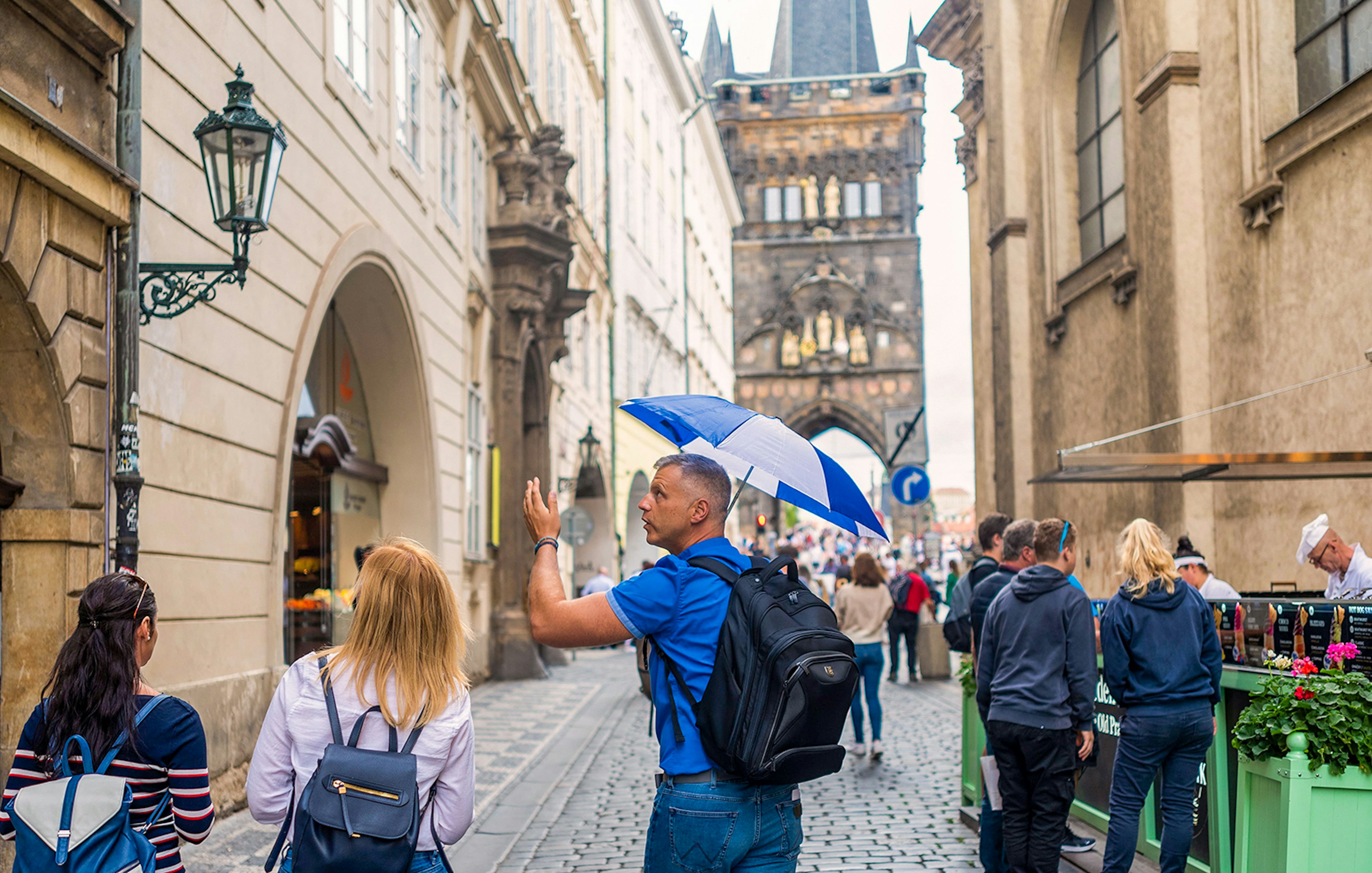 Tour guide leading group near Charles Bridge in Prague.