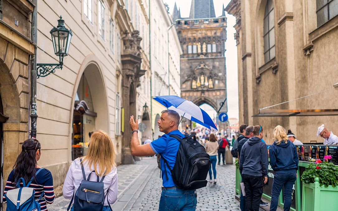 Tour guide leading group near Charles Bridge in Prague.