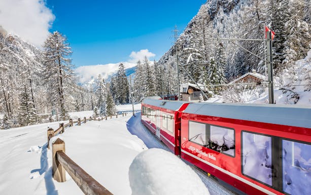 Bernina Express traveling through snowy Swiss Alps landscape from Milan.