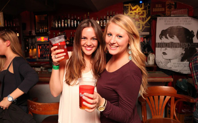 Two people enjoying drinks at a bar during a Prague pub crawl.