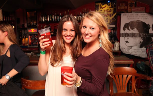 Two people enjoying drinks at a bar during a Prague pub crawl.