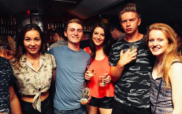 Group enjoying drinks at a lively bar during Prague Pub Crawl.