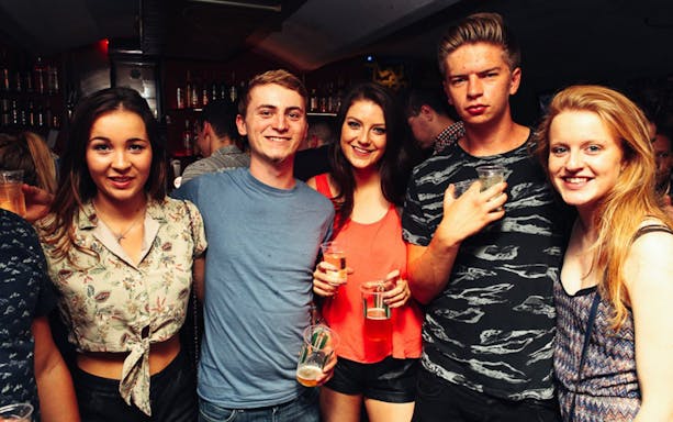 Group enjoying drinks at a lively bar during Prague Pub Crawl.