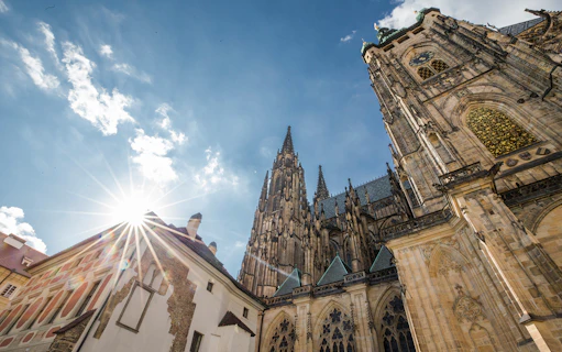 Prague Castle complex with Gothic architecture under a sunny sky.