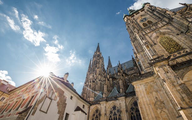 Prague Castle complex with Gothic architecture under a sunny sky.