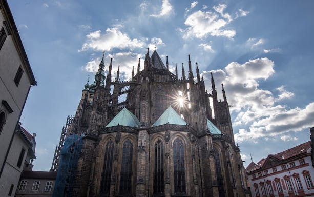 Prague Castle Complex with sun shining through Gothic architecture.