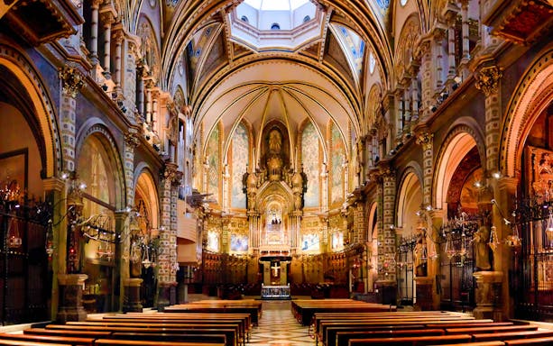 Interior of Montserrat Basilica with view of altar and ornate arches, part of the morning tour.