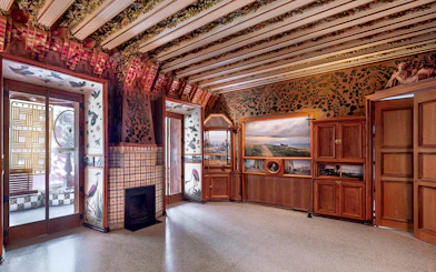 Casa Vicens interior with ornate ceiling, decorative tiles, and wooden cabinets in Barcelona.