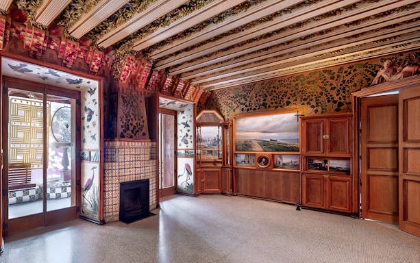 Casa Vicens interior with ornate ceiling, decorative tiles, and wooden cabinets in Barcelona.