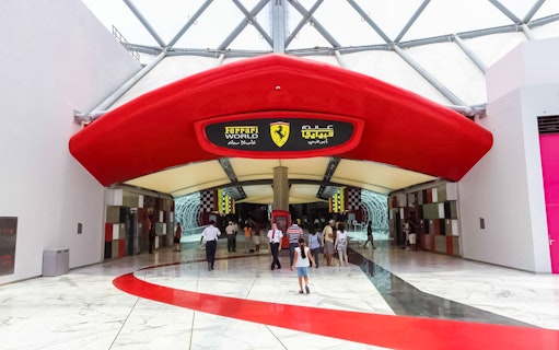Entrance to Ferrari World Abu Dhabi with visitors walking inside.