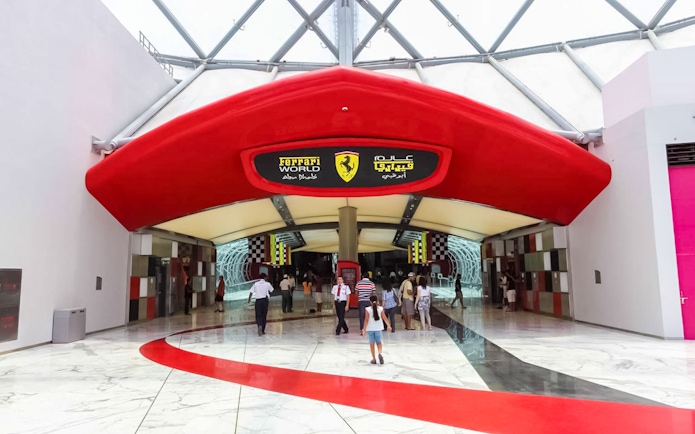 Entrance to Ferrari World Abu Dhabi with visitors walking inside.
