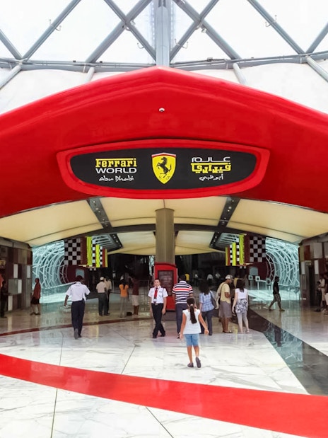 Entrance to Ferrari World Abu Dhabi with visitors walking inside.