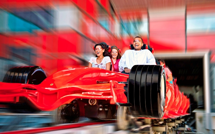 Visitors enjoying a high-speed roller coaster ride at Ferrari World Abu Dhabi.