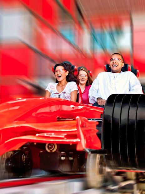 Visitors enjoying a high-speed roller coaster ride at Ferrari World Abu Dhabi.