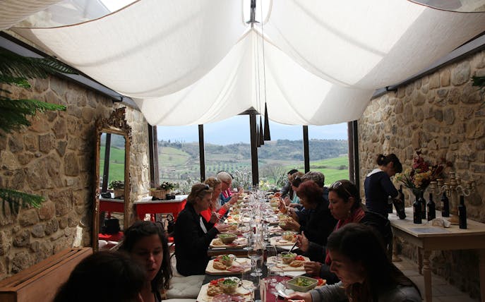 Guests enjoying a meal with wine at a vineyard estate in the Rome countryside.