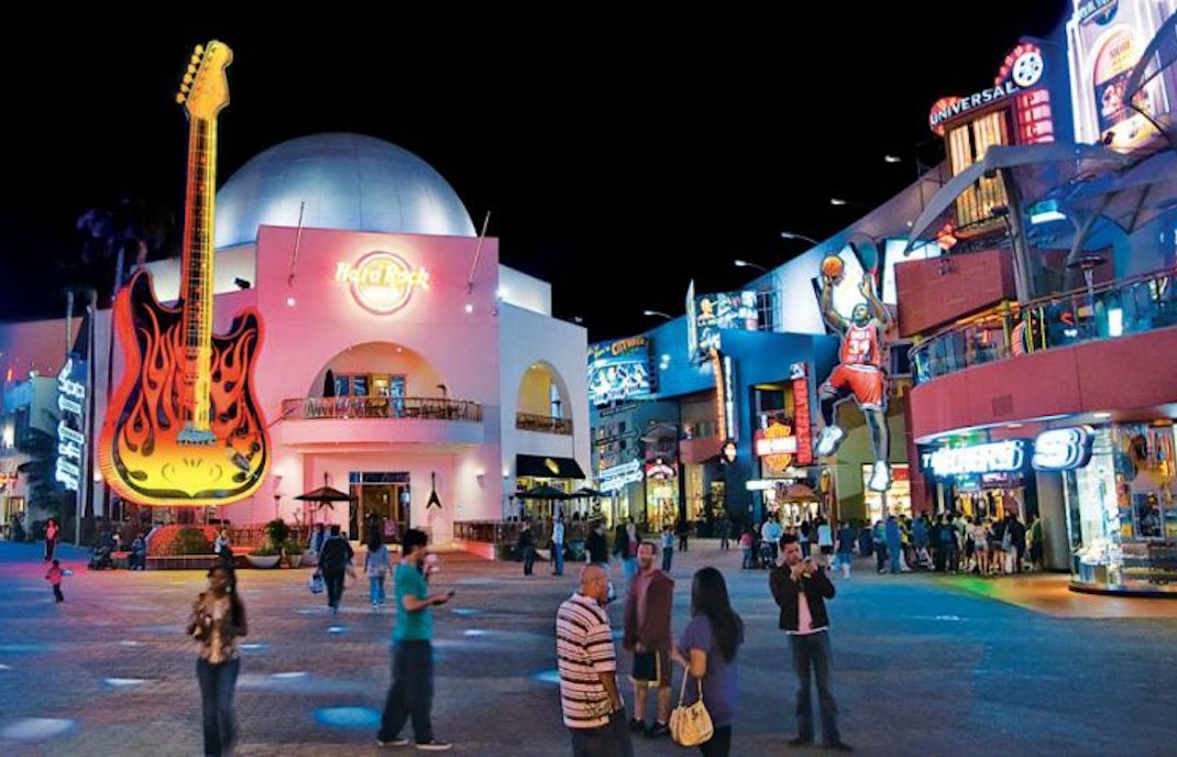 Universal Studios Hollywood CityWalk at night with neon signs and visitors.