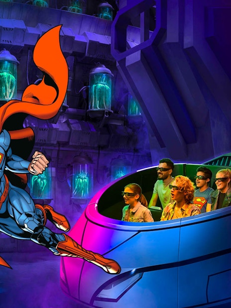 Visitors on a 3D ride at Warner Bros. World Abu Dhabi with Superman flying nearby.