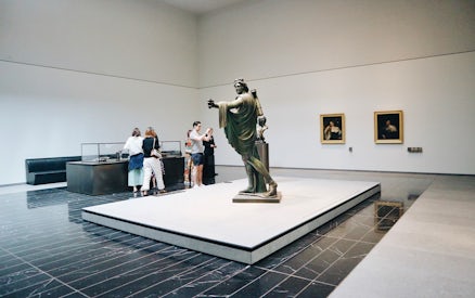 Visitors viewing art and sculptures at the Louvre Museum in Abu Dhabi.