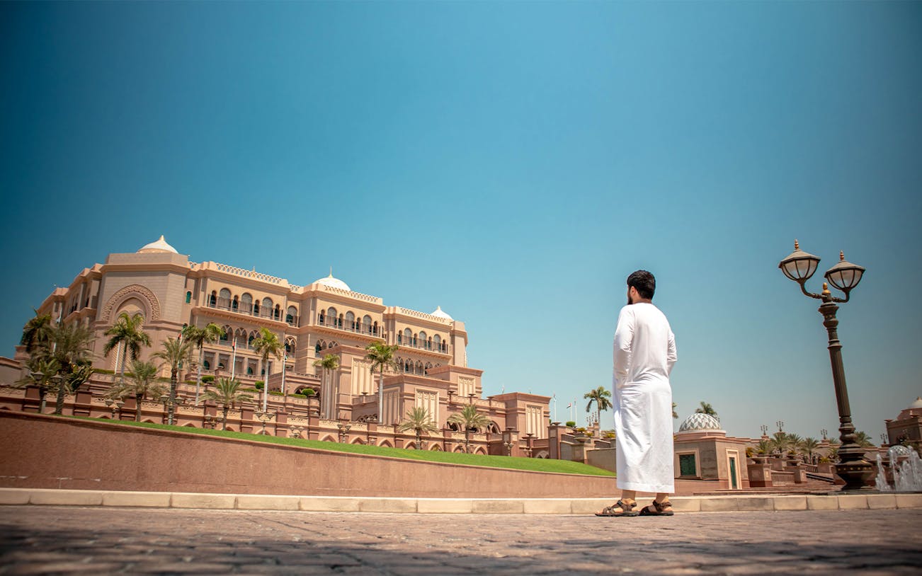 Man standing outside the Emirates Palace in Abu Dhabi during city tour.
