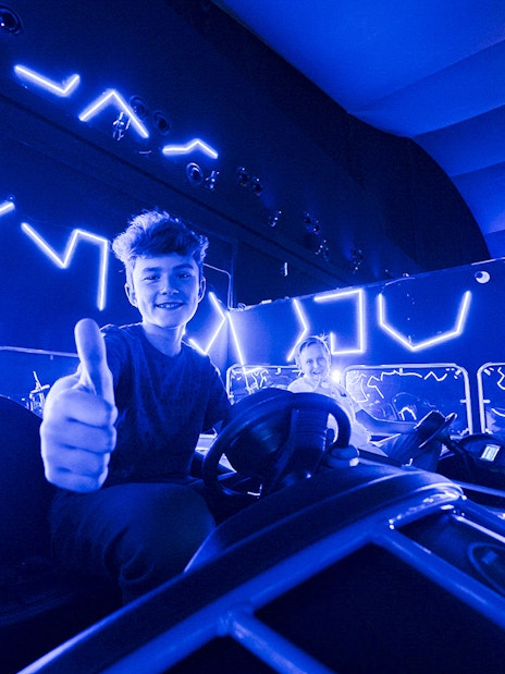 Young person enjoying bumper cars at IMG World Dubai.