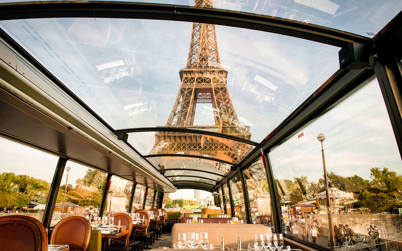 Interior view of La Marina Orsay lunch cruise with Eiffel Tower through glass ceiling, Paris.